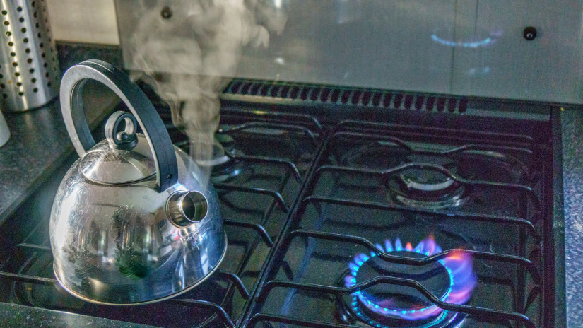 Steam escaping from kettle boiling on gas hob