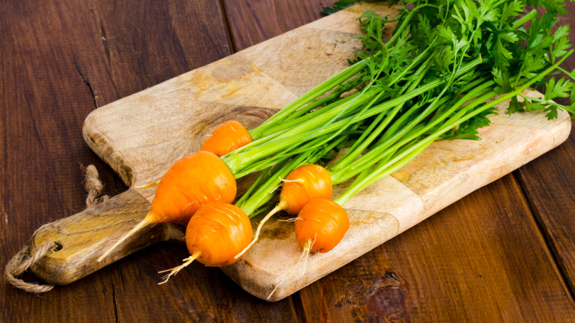 Bunch of small, round carrots (Parisian Heirloom Carrots) on wooden background. Studio Photo