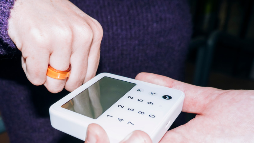 Customer using contactless payment ring for transaction on pos terminal