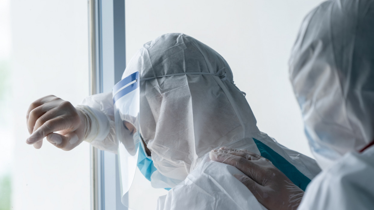 Tired doctor in PPE suit in the lab,Doctor wearing protective suit to fight coronavirus pandemic covid-2019,Overworked doctor,Coronavirus has turned into a global emergency.