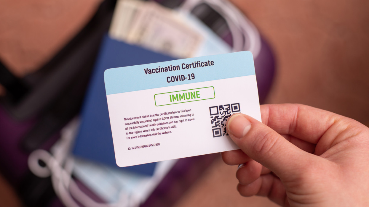 Covid-19 vaccination certificate in hand of a immune person