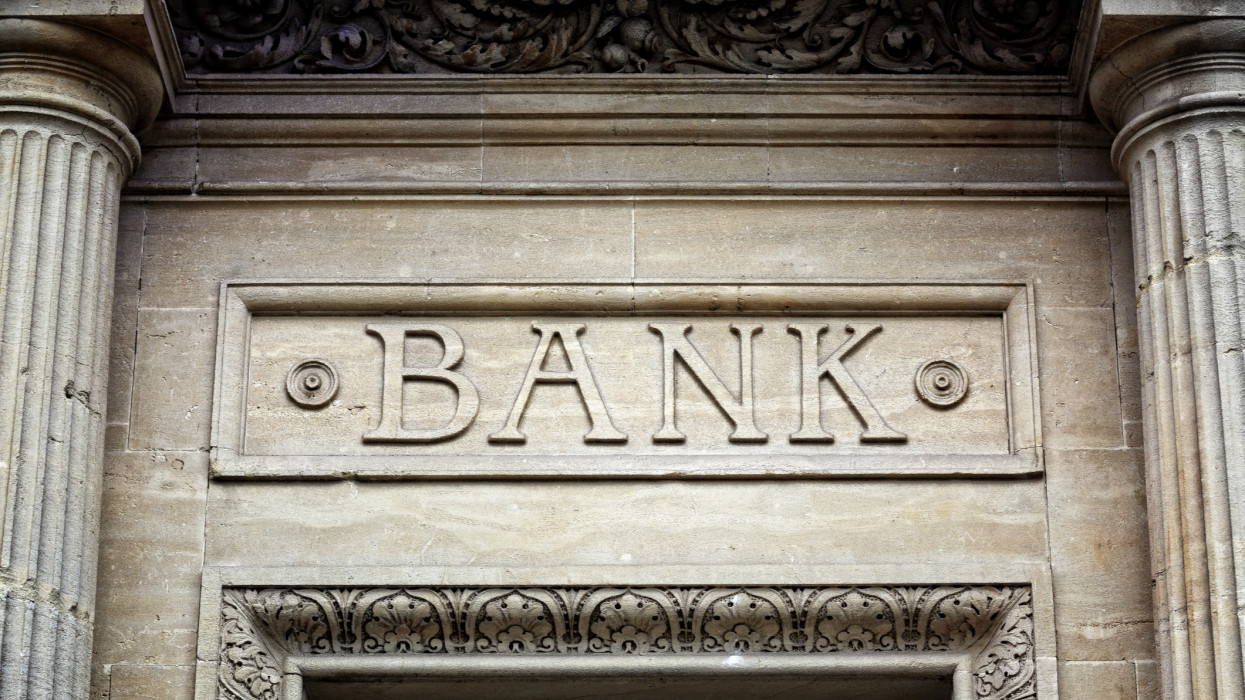 Old bank sign engraved in stone or concrete above the door of financial building concept for finance and business