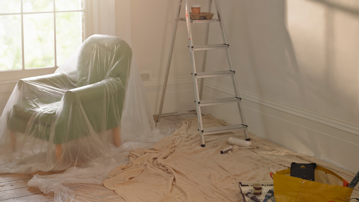 A room with dust sheets, A ladder and paint roller