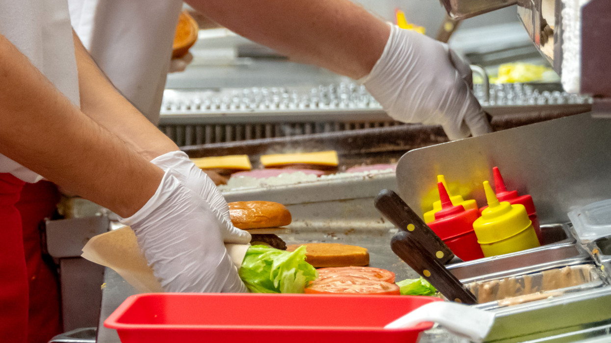 Fast food workers working in a hamburger restaurant close up