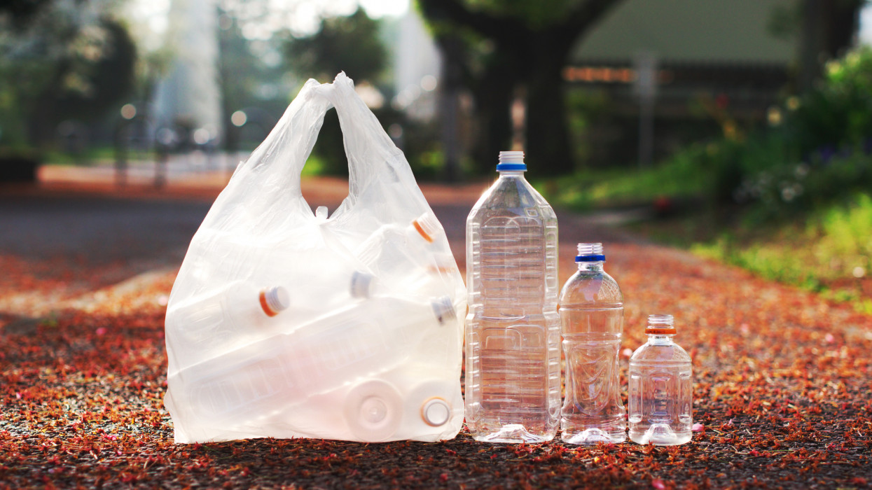 A bag of PET bottle and three loose PET bottles ready to be taken to recycle bin.