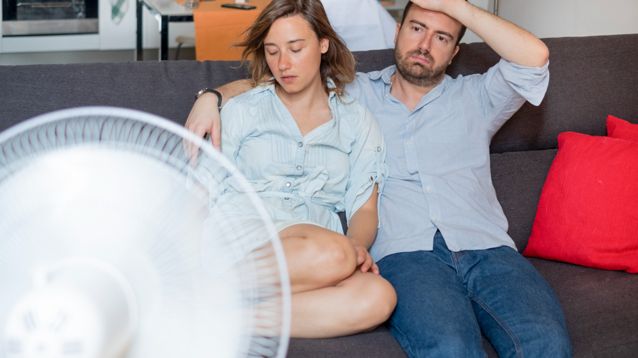 Stressed couple trying to refresh from summer heatwave