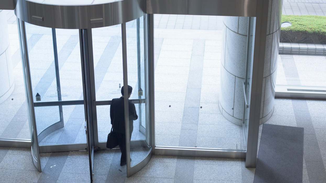 Businessman leaving the revolving door of the office building
