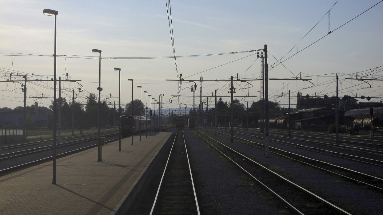 Trains on many sets of tracks at a railway station.