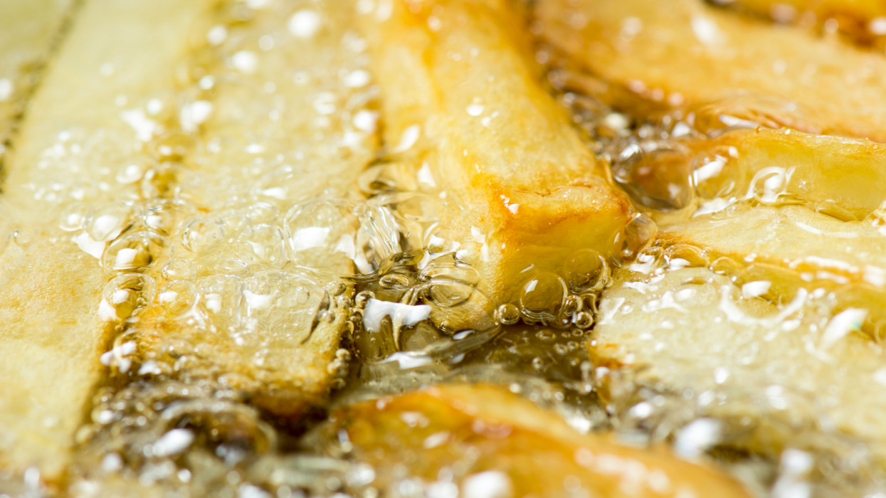 extreme closeup of fried potatoes in hot bubbling oil