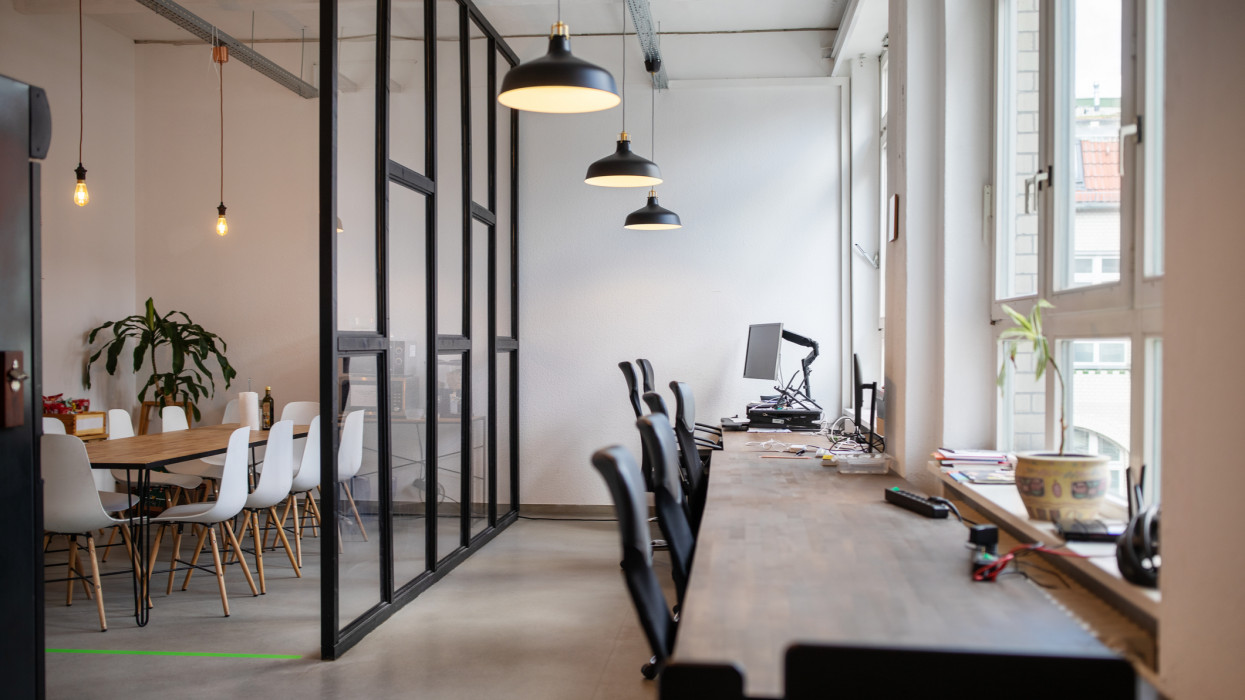 Creative workplace interior with over hanging lamps. Interior of coworking workplace.