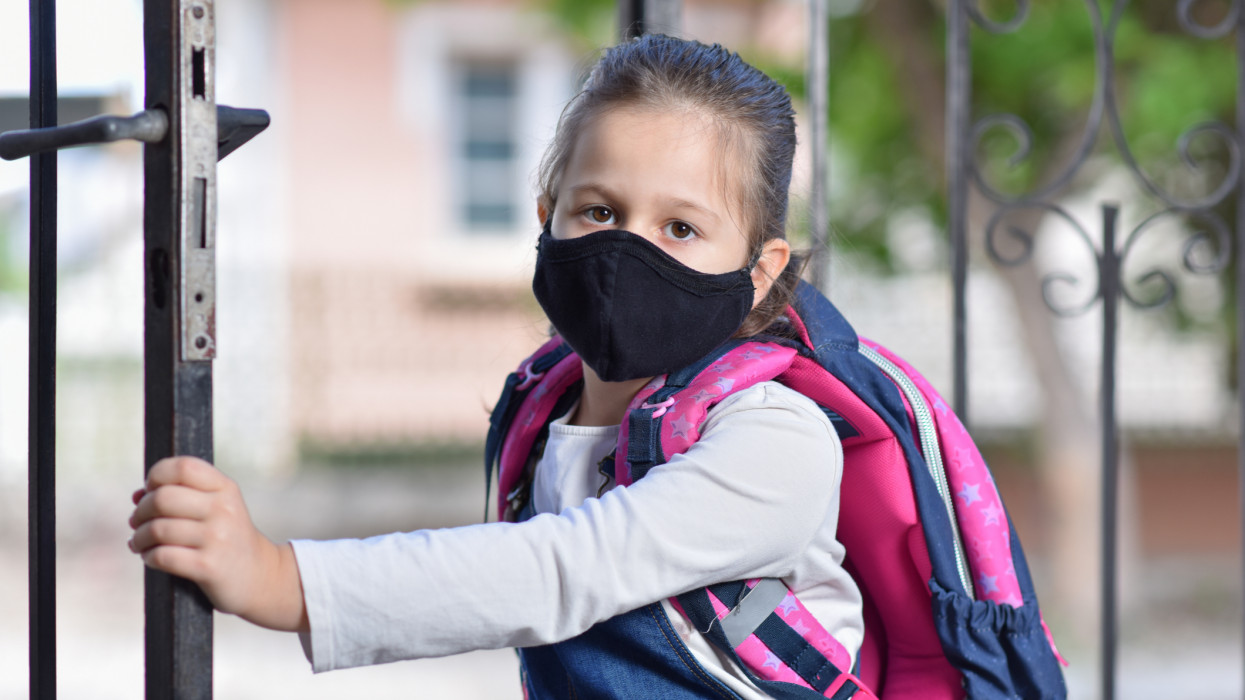 Portrait of girl with protective mask going in school during covid-19 pandemic in year of 2020