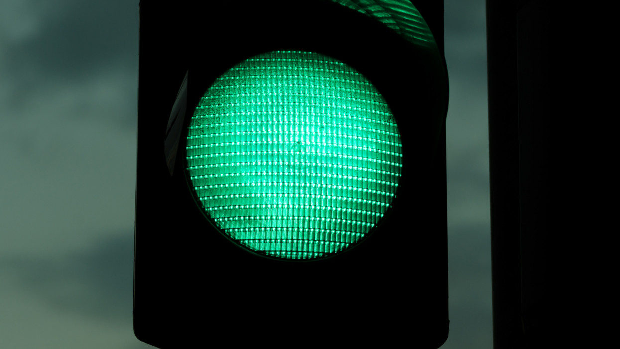 Night close up image of green traffic light. With film grain/noise.