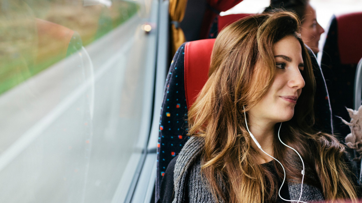 A young woman travelling with bus while listening music