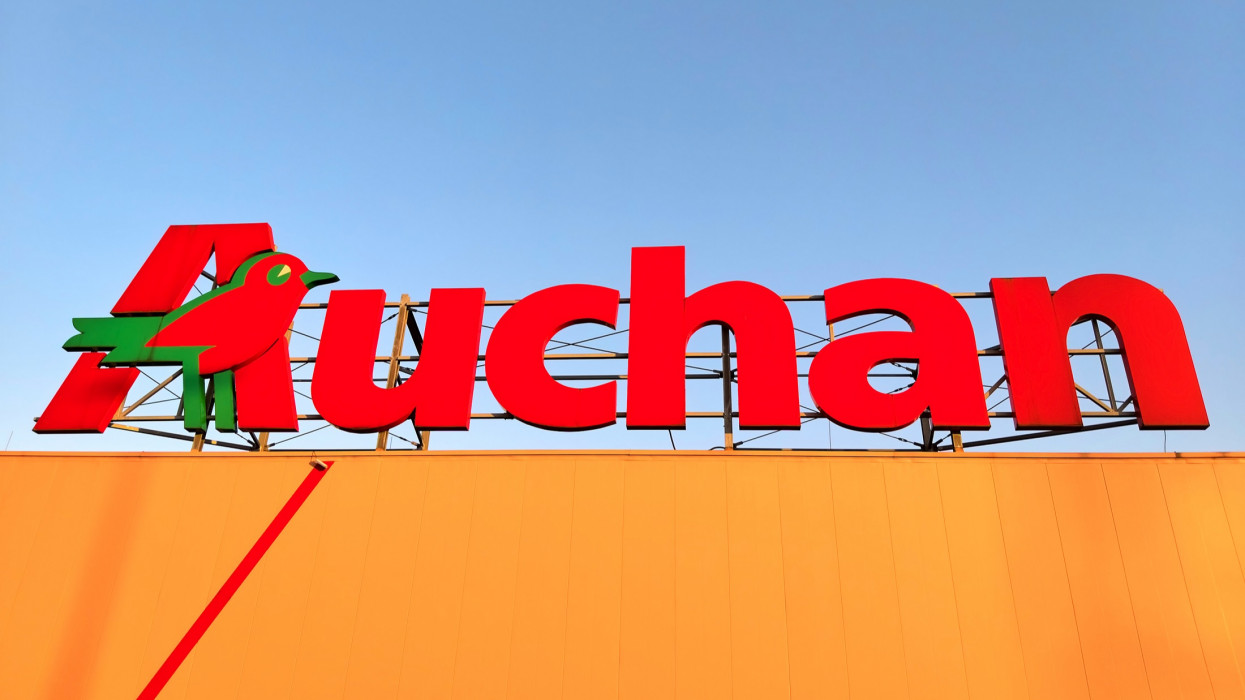 Lomianki, Poland - July 6, 2021. Auchan supermarket logo atop the shopping center.