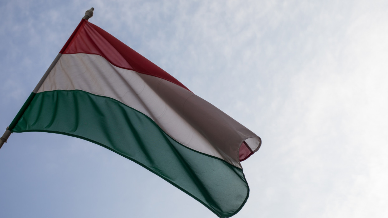 The flag of Hungary flying against a blue sky in Budapest.