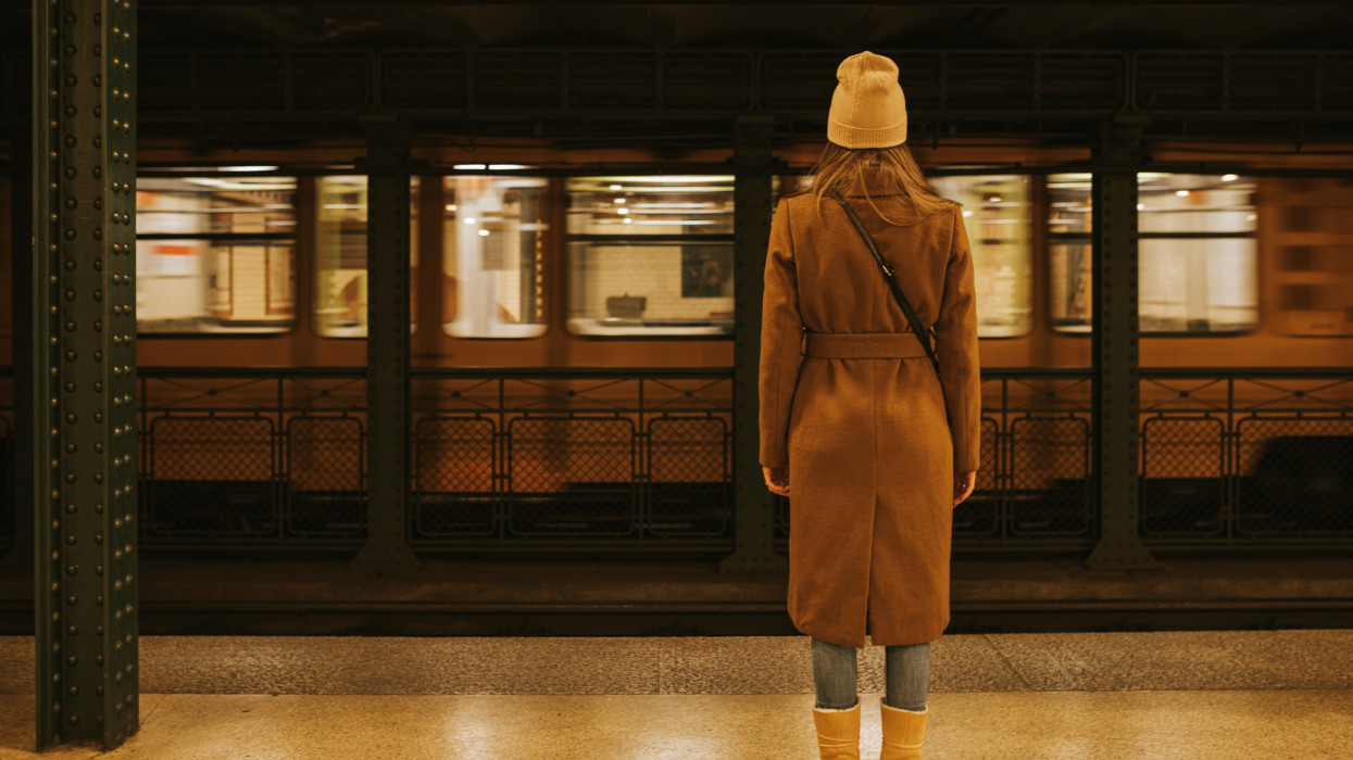 Nő áll üres metróállomáson