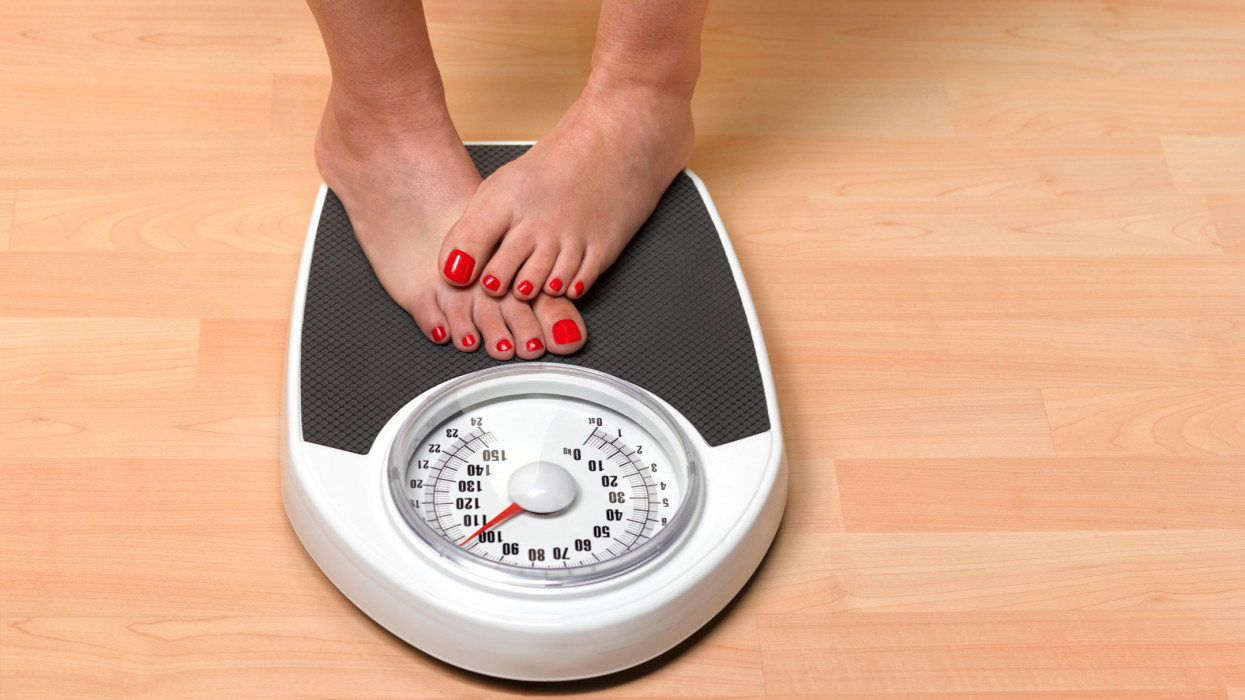 Obese woman weighing herself