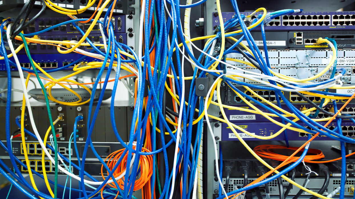 A tangled mess of network cables in a server room