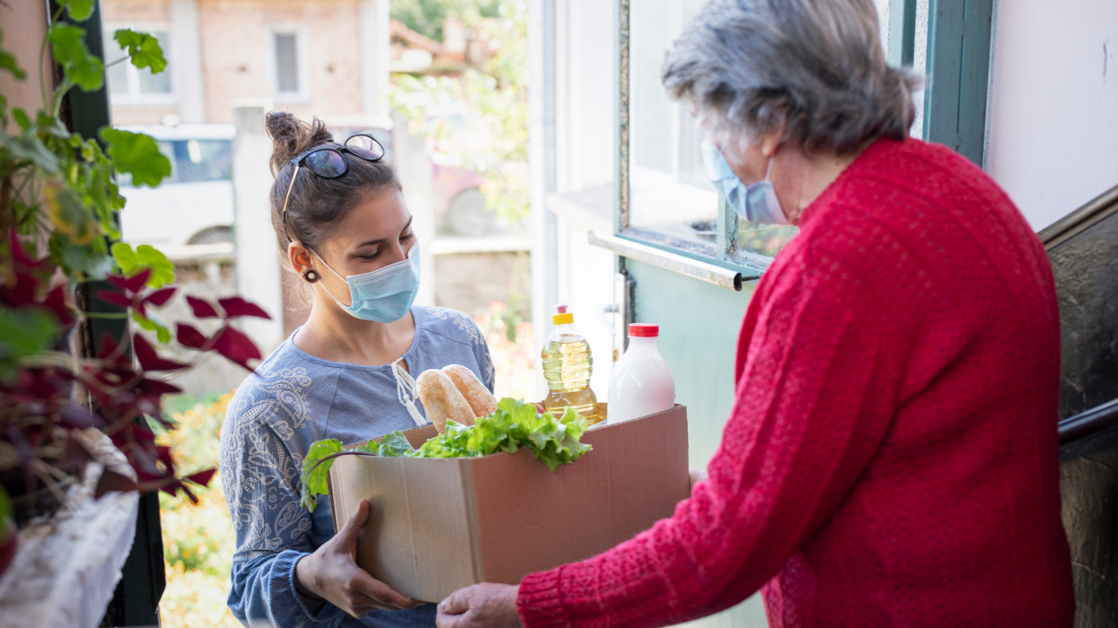 Woman delivering box with products to grandmother.