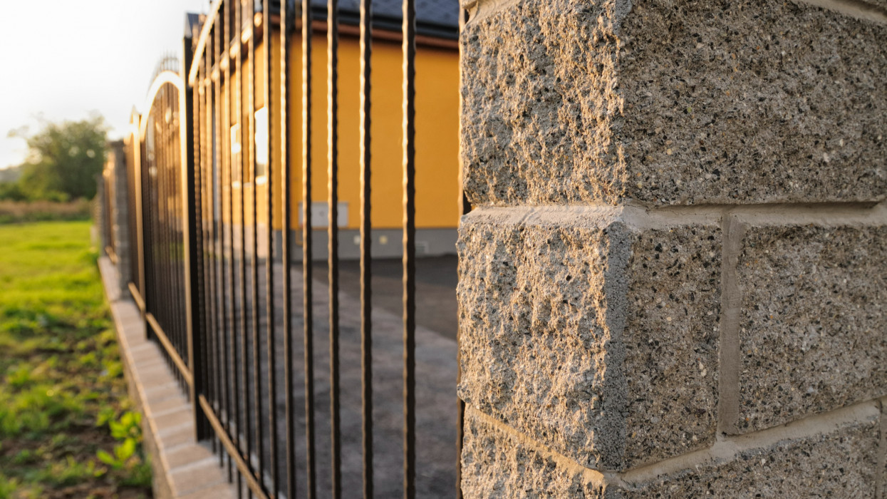 Iron fence ending with decorative concrete blocks