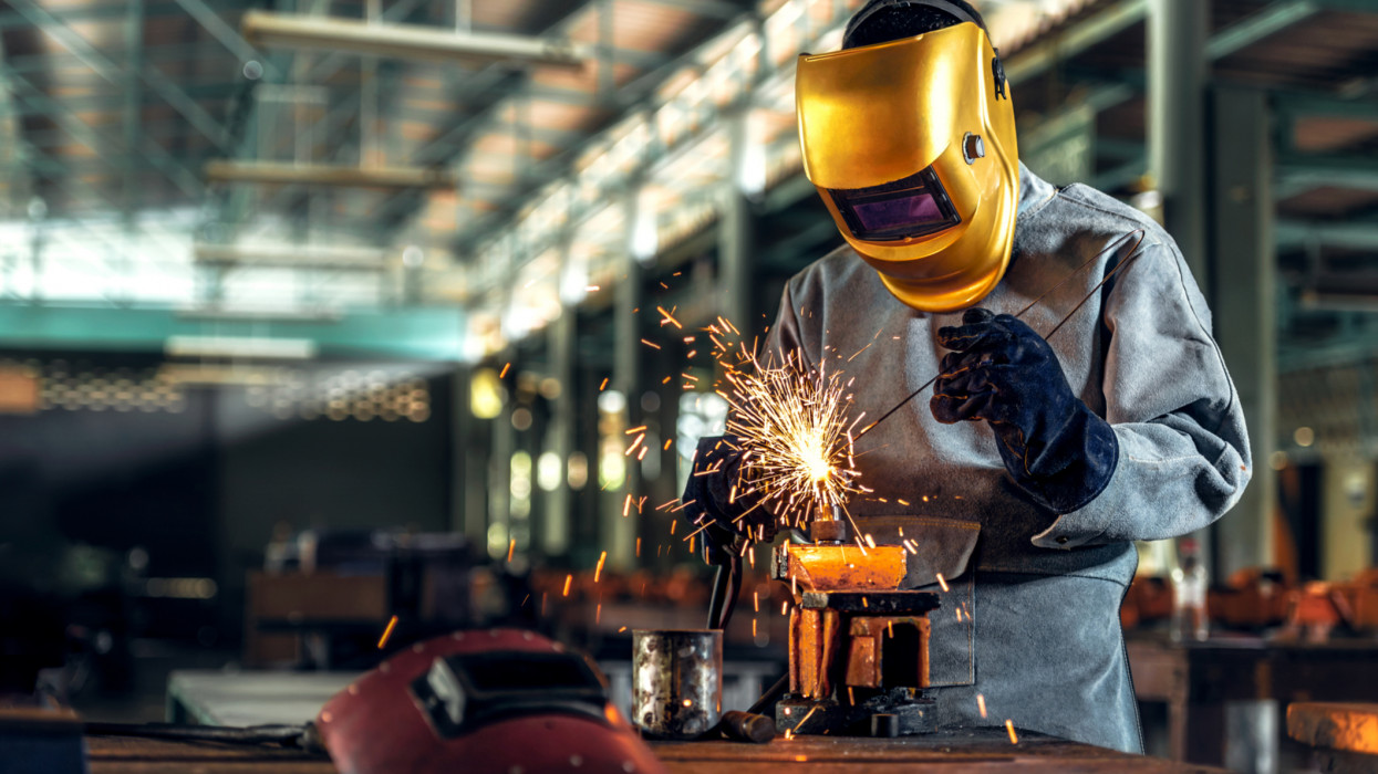 Worker welder working welding steel in industry with safety mask safety gloves and safety equipment. Worker welding concept.