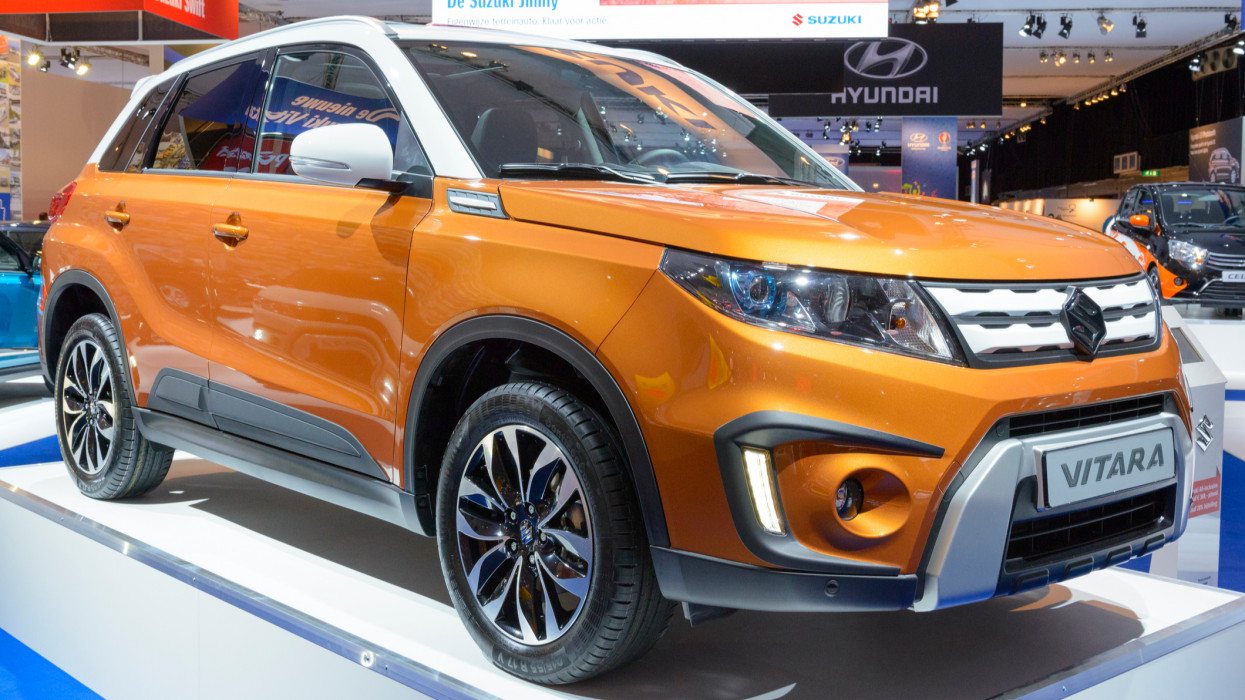 Amsterdam, The Netherlands - April 16, 2015: Suzuki Vitara compact crossover SUV on display during the 2015 Amsterdam motor show. People in the background are looking at the cars.