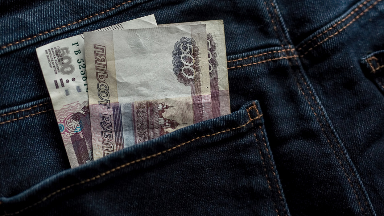 Paper bills of money in the back pocket of a pair of jeans.