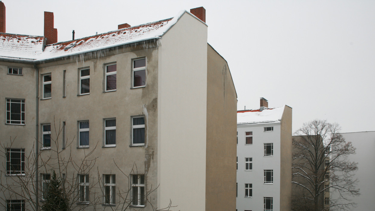 Snow on residential buildings and bare winter trees in Berlin, Germany