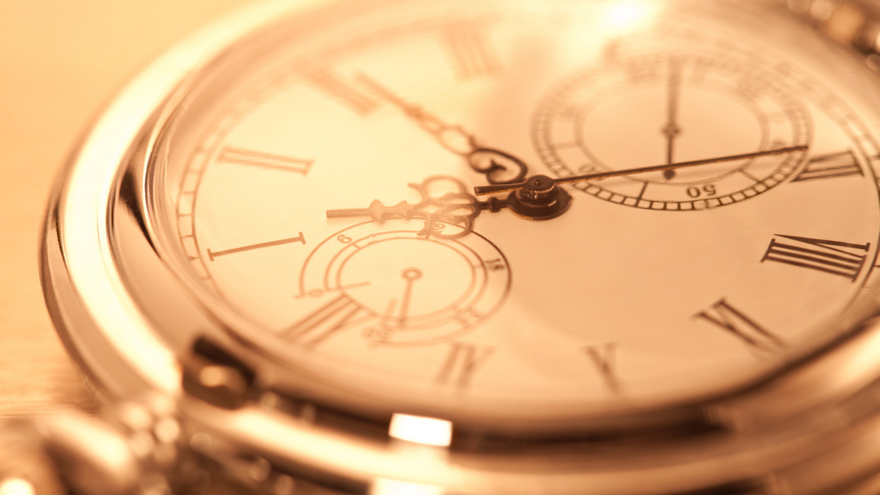 Cropped image of pocket watch over isolated background