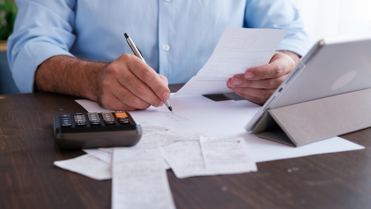 Man calculating personal expenses at home