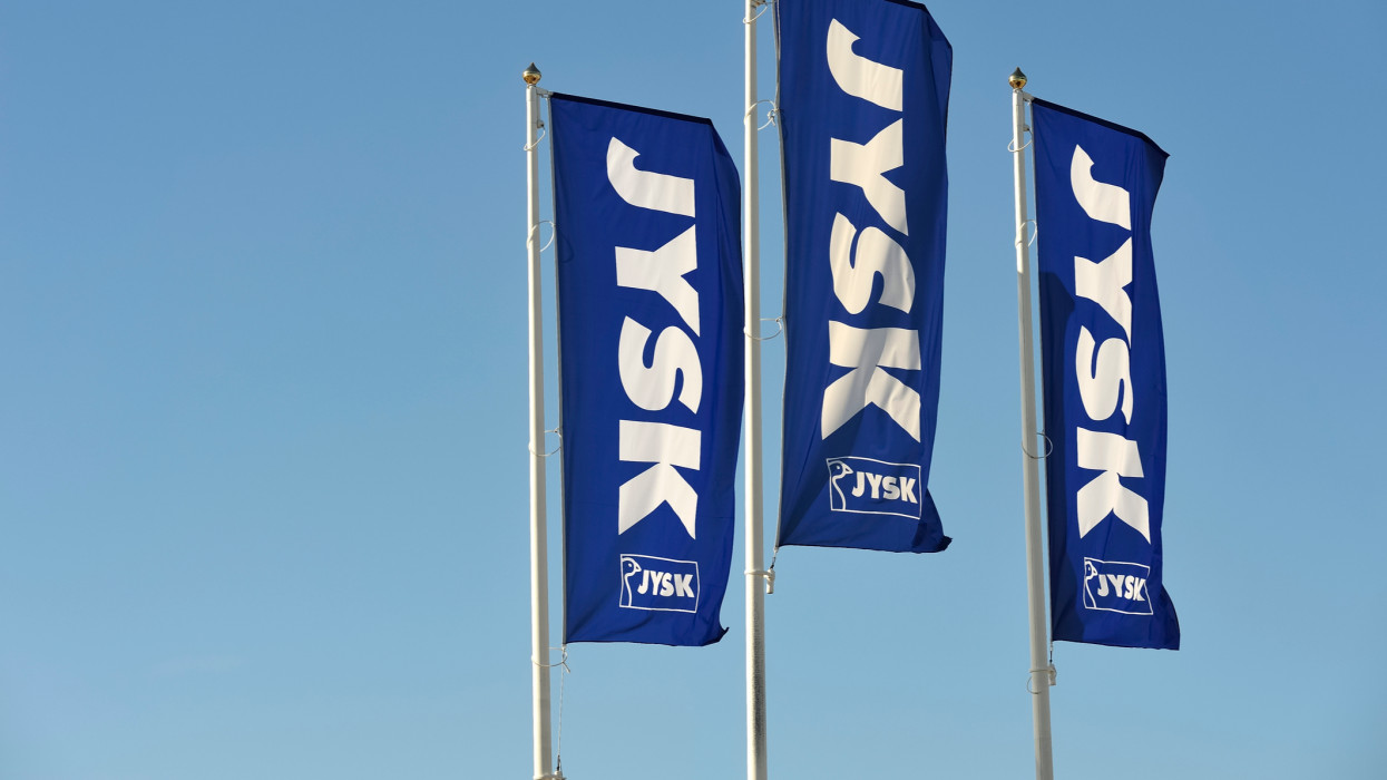 Stockholm, Sweden - April 30, 2013: Jysk flag against blue sky. JYSK is a Danish company. JYSK sell mattresses, duvets, pillows, furniture and furnishings.
