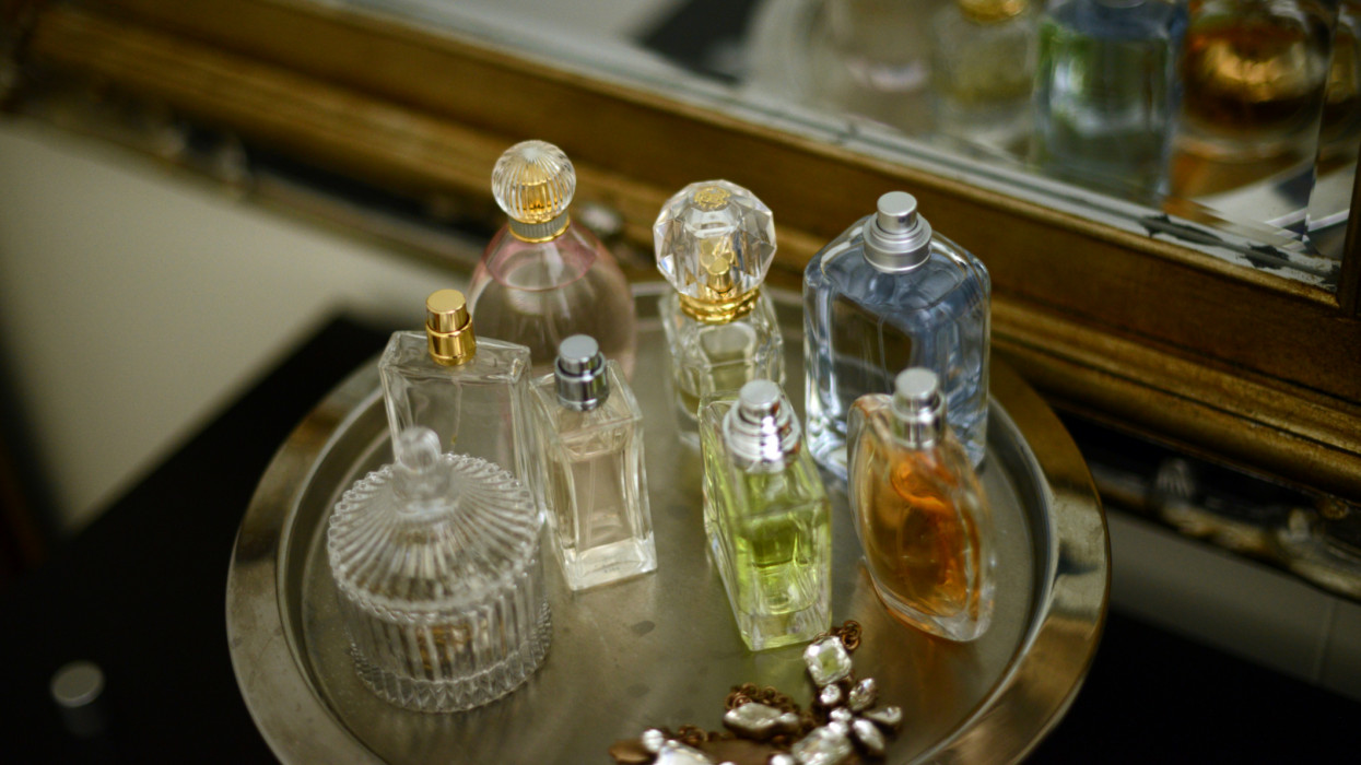 Perfume bottles on a silver tray by an antique mirror