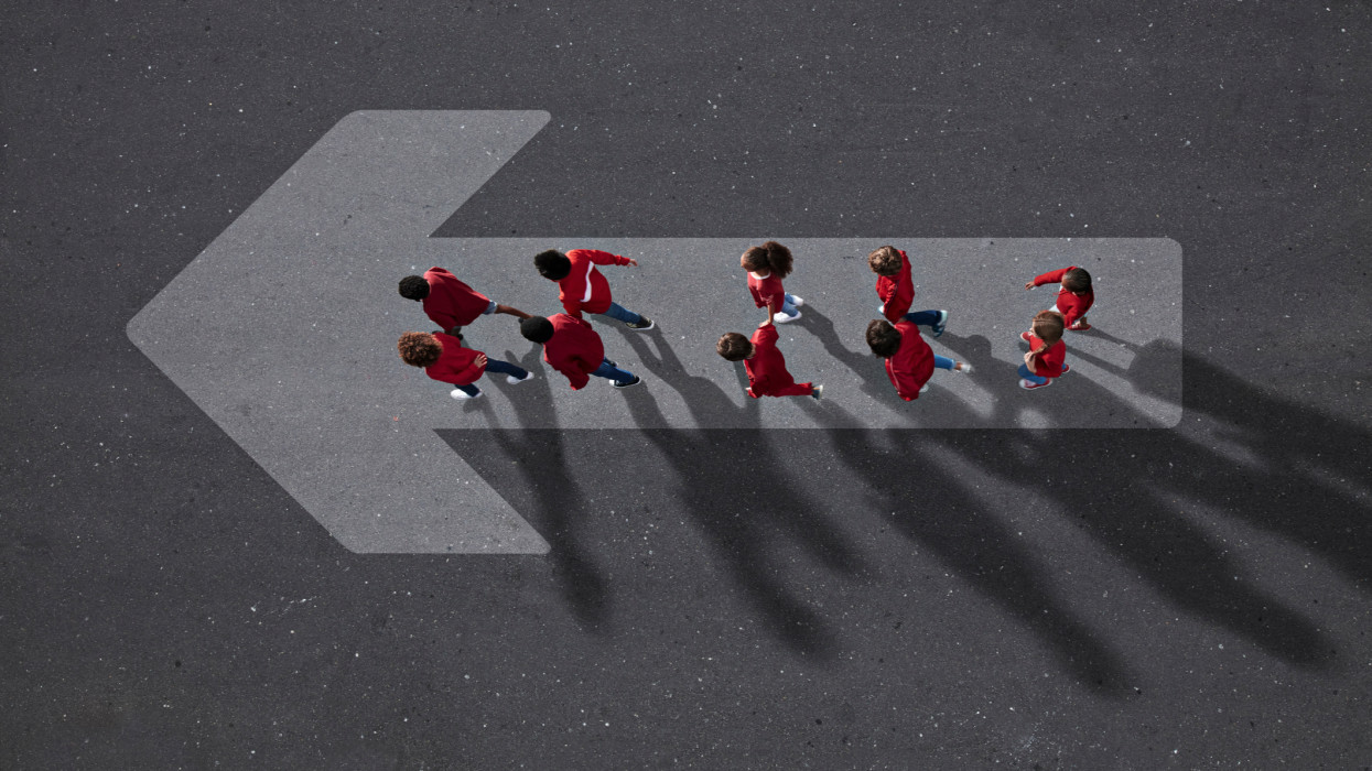 Group of children photographed from above on various painted tarmac surface at sunset