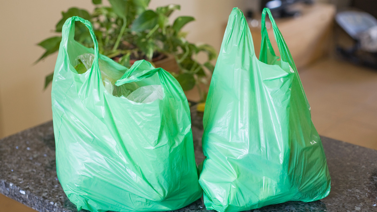 Green plastic bags on kitchen worktop.