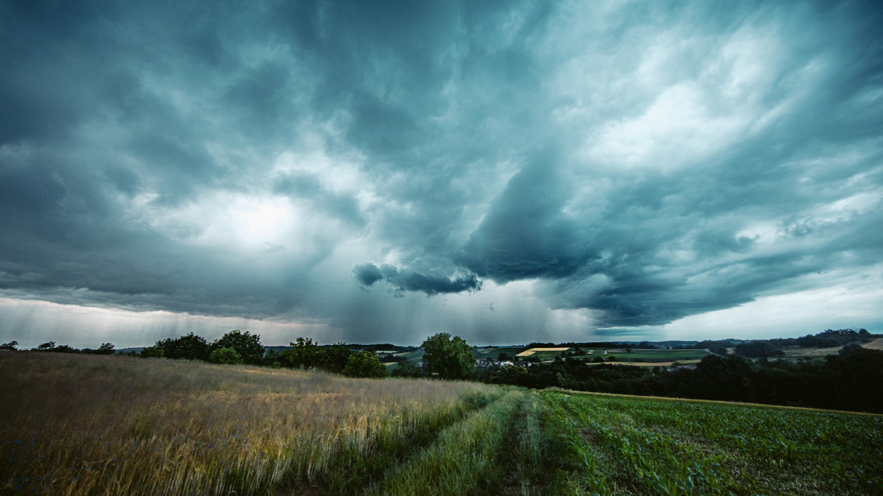 Storm cloudscape over grass field
