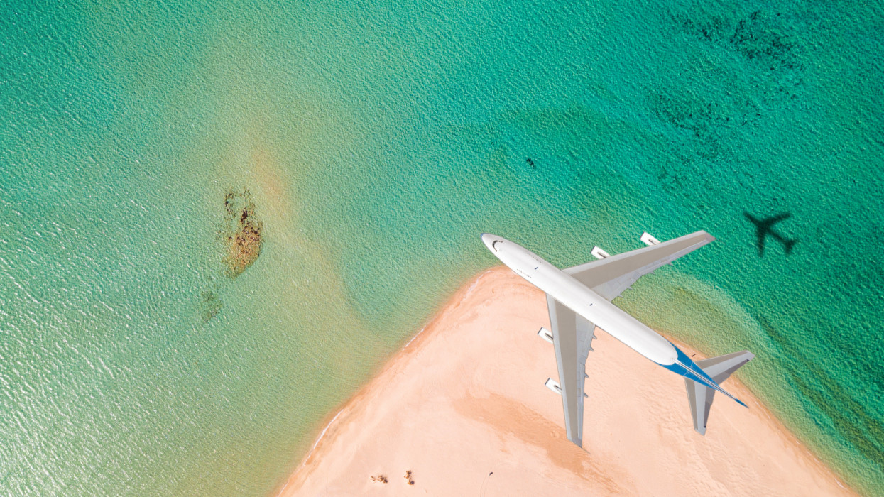 This is a photo of an airplane flying above the beach
