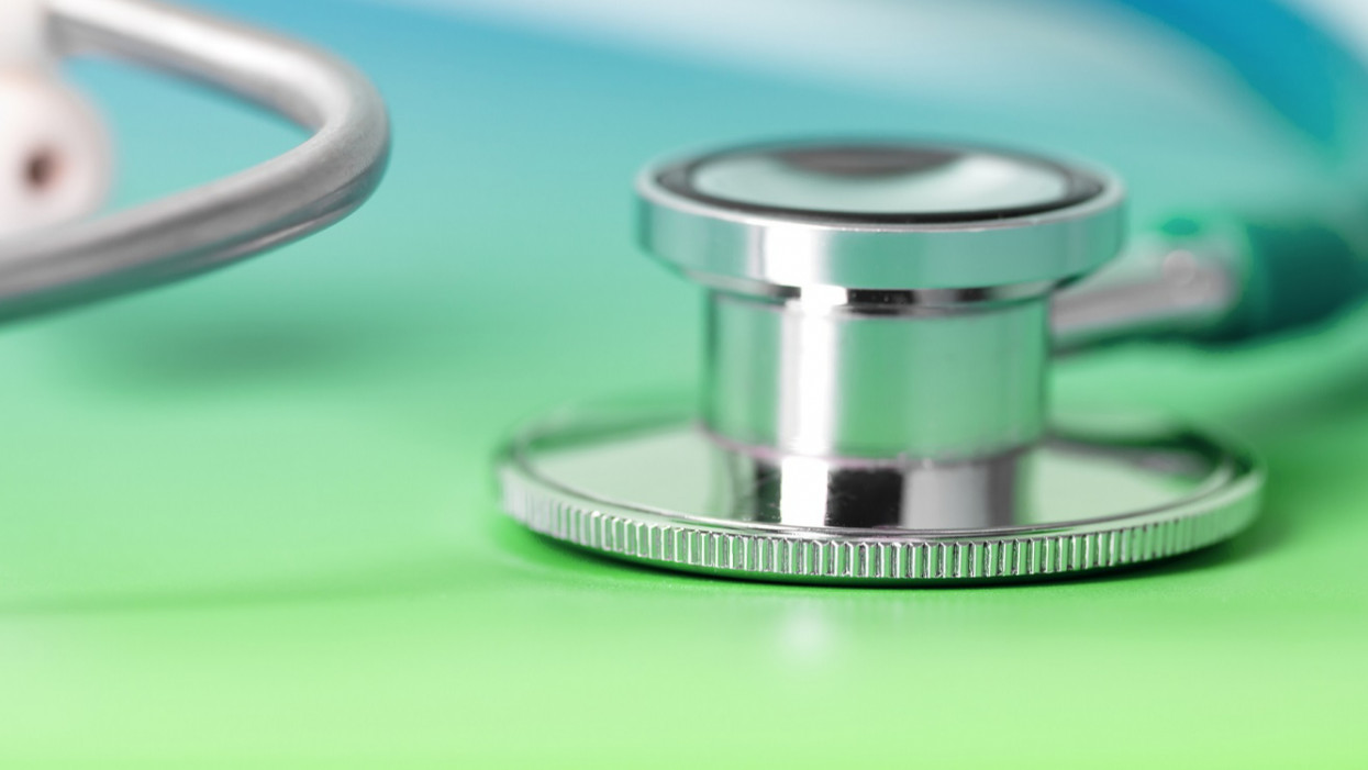 Close-up of a stethoscope on a green folder. Space for copy, shallow depth of field.