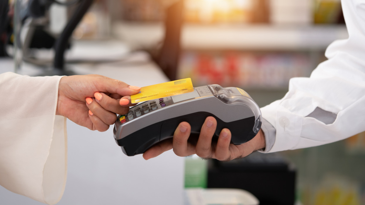 credit card payment service. Customer paying for order of cheese in grocery shop.Credit card payment service The customer pays to order cheese in the pharmacy.