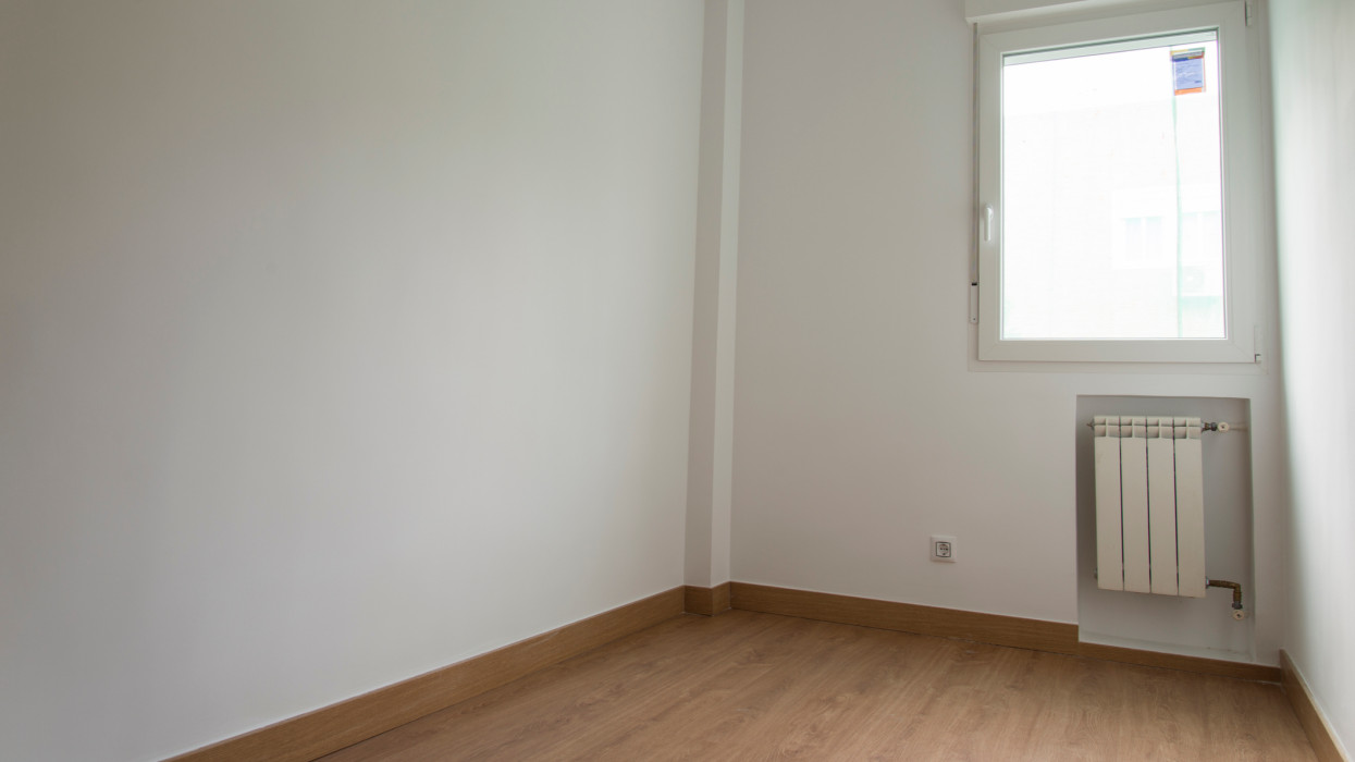Wide angle view of tiny white bedroom without furnitures ready to be inhabited after renovation. Small aparment in Madrid, Spain.