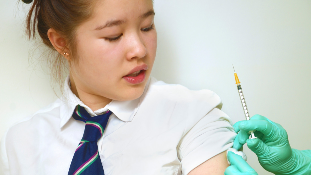 Close up of a schoolgirl having an injection