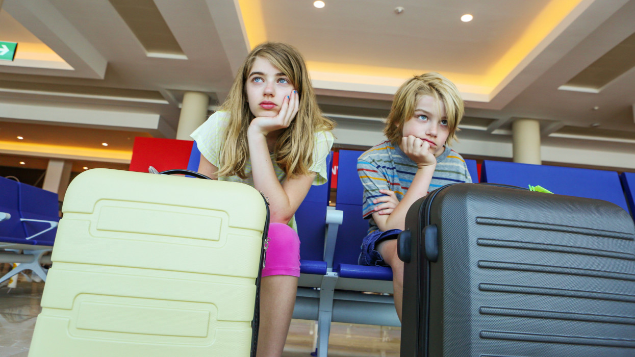Kids waiting for flight in airport looking very bored