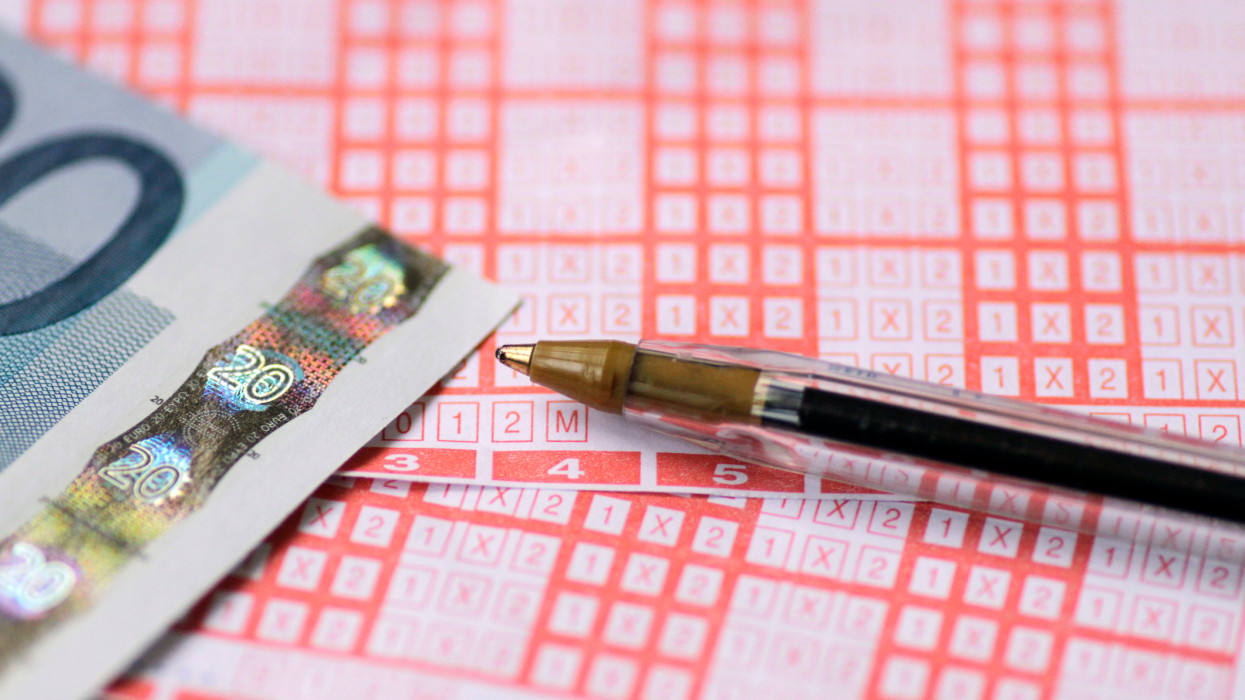 Close-Up Of Sports Betting Ticket, Euro Bills And Pen