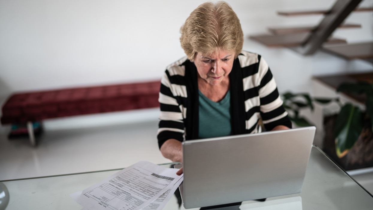 Focused senior woman using laptop at home