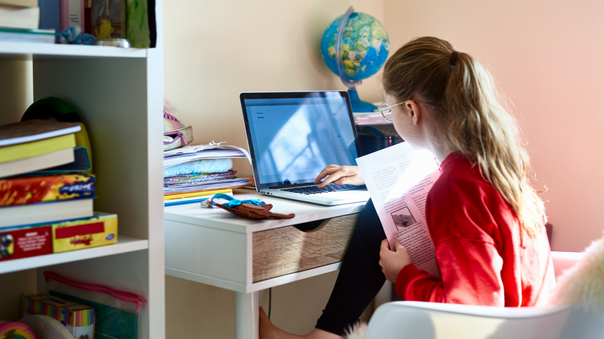 9 year old child sitting at desk doing homework on computer, homeschooling, self development, motivation, improvement