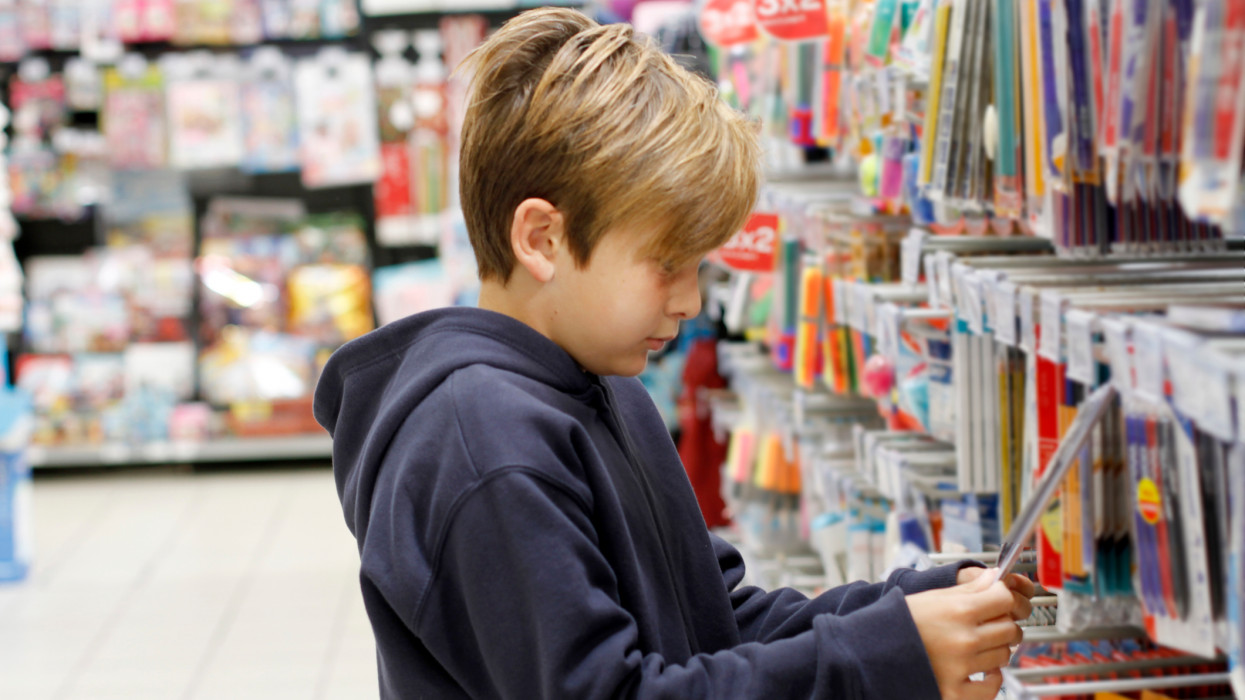 Boy shopping for school supplies in a supermarket