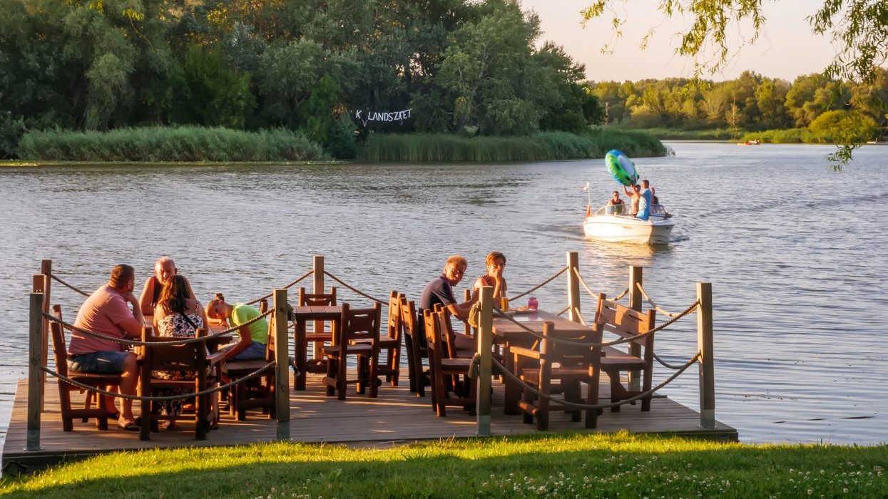 TISZAFURED, HUNGARY - AUGUST 08, 2020: View of the people having dinner by the Tisza lake in Tiszafured, Hungary on a summer afternoon.