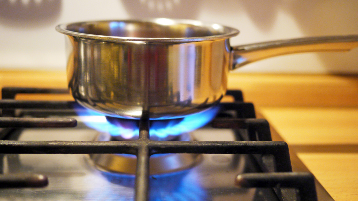 Blue methane flames reflecting, detail of kitchen.