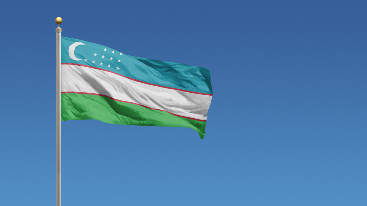 Flag of Uzbekistan in front of a clear blue sky