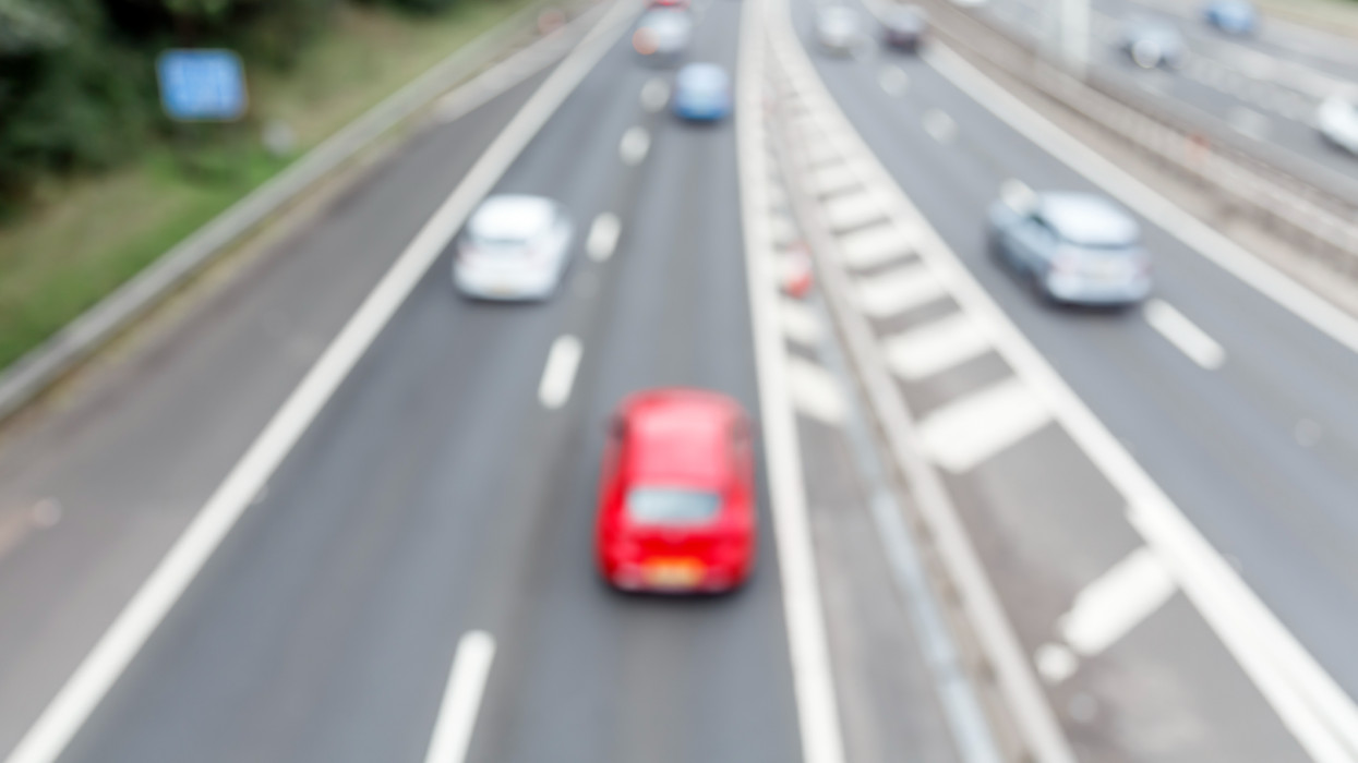Defocused photograph looking down to vehicles on a motorway travelling away from the camera