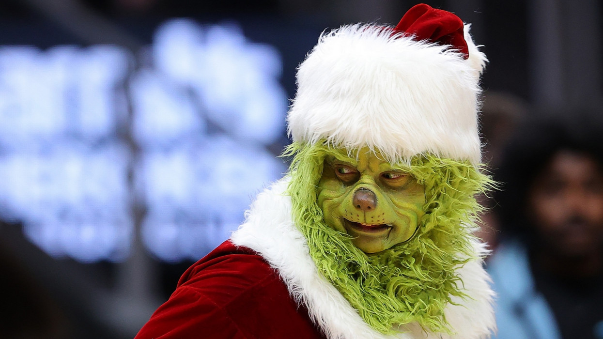 ATLANTA, GEORGIA - DECEMBER 22:  The Grinch character is seen tossing out shirts during the first half between the Atlanta Hawks and the Orlando Magic at State Farm Arena on December 22, 2021 in Atlanta, Georgia.  NOTE TO USER: User expressly acknowledges and agrees that, by downloading and or using this photograph, User is consenting to the terms and conditions of the Getty Images License Agreement.  (Photo by Kevin C. Cox/Getty Images)